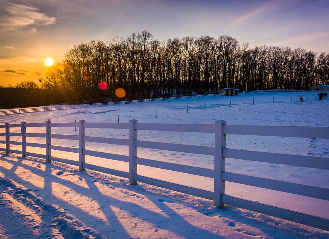 We Are Independent - Scenic View of a White Picket Fence on a Farm in Maryland with Snow on the Ground at Sunset